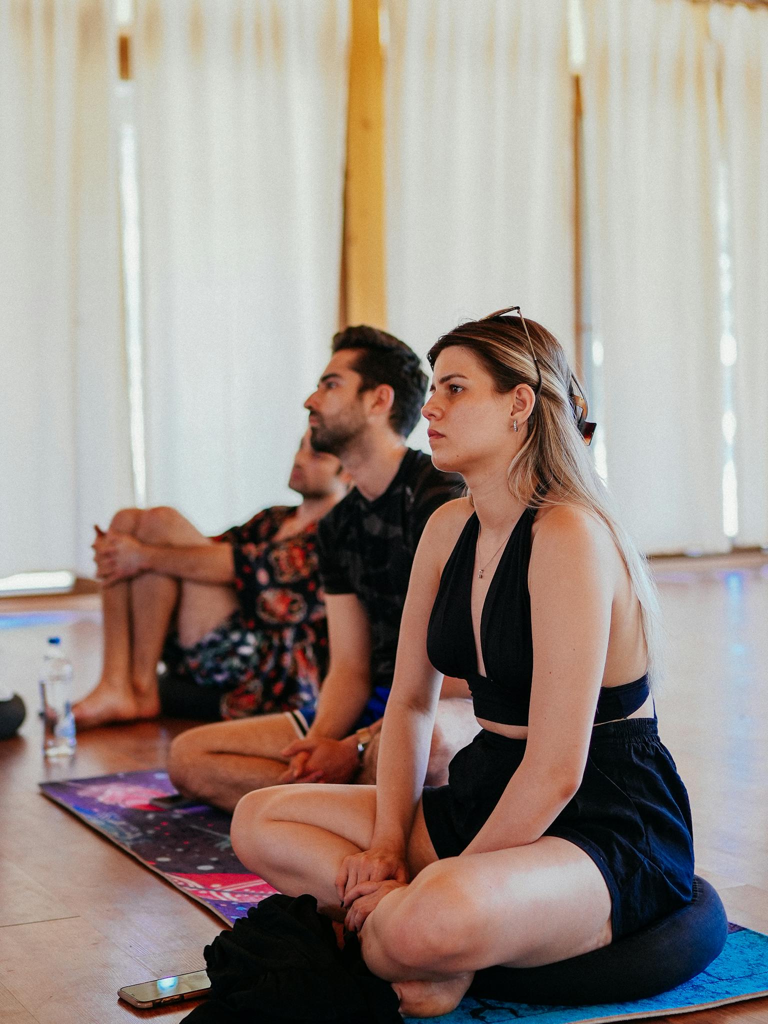 Group of adults sitting in an indoor meditation class practicing mindfulness.